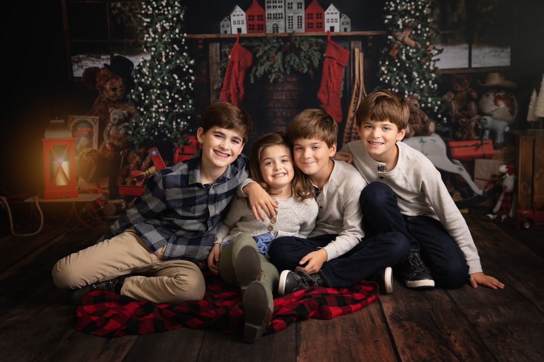 Portrait of a family of four kids taken with a Christmas backdrop by Kimberly Kendalls